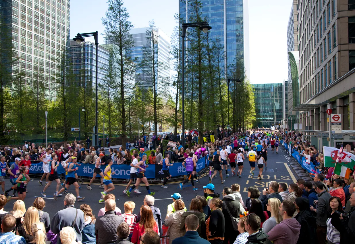 Londra Maratonu etkinliğinde, binlerce koşucu coşkulu seyirciler eşliğinde Londra'nın ikonik caddelerinden birinde koşarak ilerliyor; bu an, maratonun küresel bir spor festivali olduğunu ve katılımın heyecanını açıkça gösteriyor.