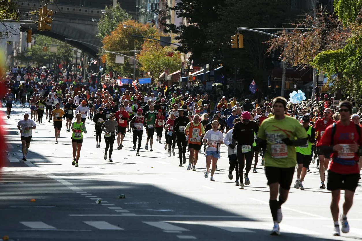 New York Maratonu'nda, şehir merkezinin kalabalık caddelerinden birinde yarışan yüzlerce maratoncu, enerji dolu anlar yaşarken, binaların gölgesinde ilerleyen rengarenk kalabalık, dayanıklılığın ve azmin bir göstergesidir.