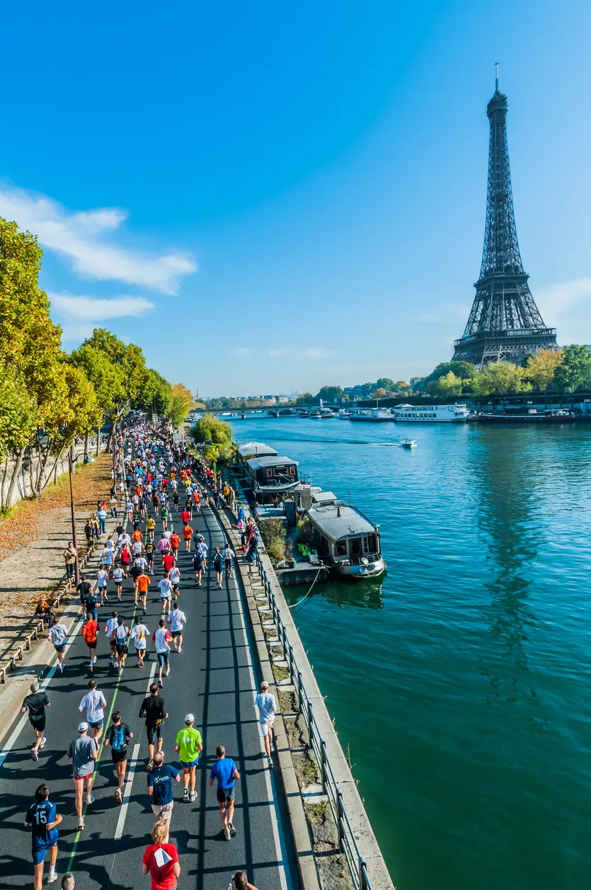 Paris Maratonu sırasında, güneşli bir günün enerjisiyle canlanan kalabalık koşucular, Paris'in zarif Haussmann mimarisine sahip binalarının ve yeşil ağaçların sıralandığı geniş caddelerinde, hedeflerine doğru kararlılıkla ilerliyor.