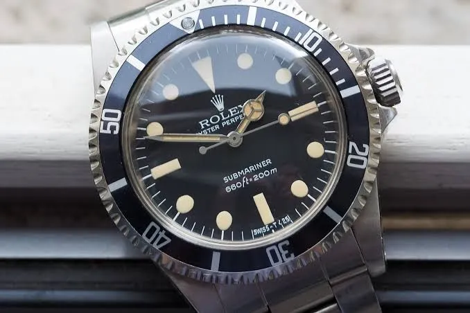 Paslanmaz çelik kasalı, siyah kadranlı, ışıklı indekslere ve Mercedes ibrelere sahip, siyah dönen bezelli klasik bir Rolex Submariner Ref. 5513 dalgıç saatinin detaylı bir yakın çekimi, tarihsel değeri ve ikonik tasarımıyla öne çıkan bu modeli sergiliyor.