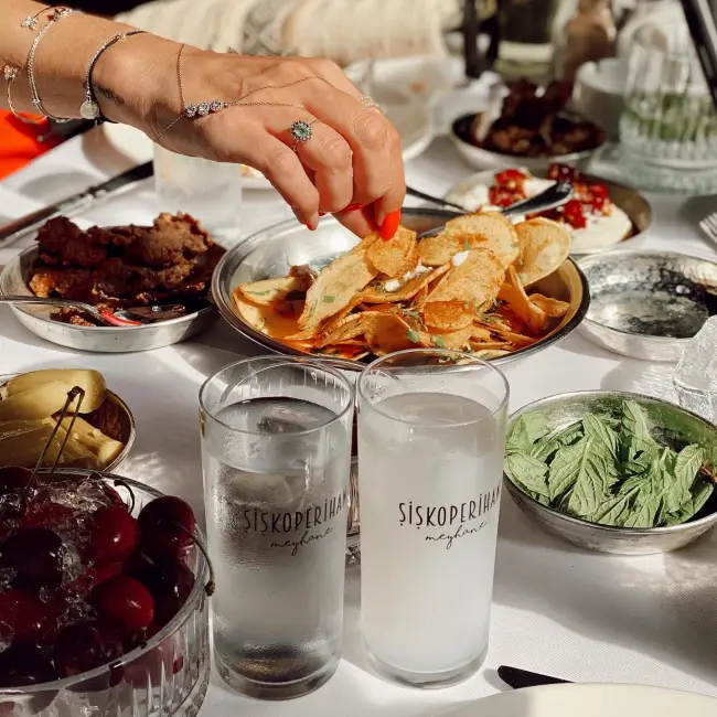Arnavutköy’de yer alan Şişko Perihan meyhanesinde dövme bakır tabaklarda sunulan meze çeşitleri ve rakı eşliğinde nostaljik bir sofra düzeni.