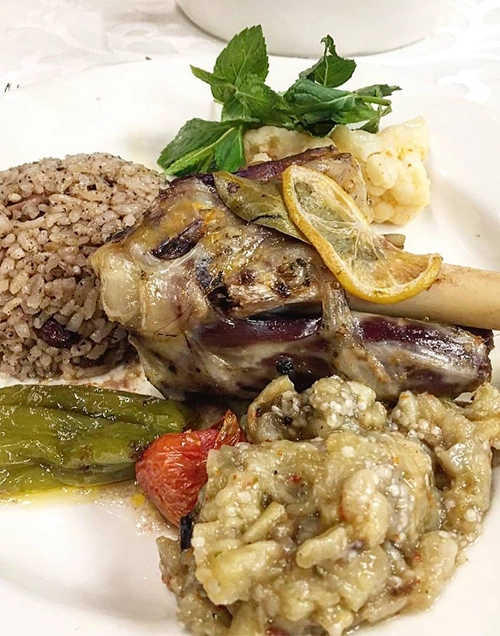 Kayseri’nin en beğenilen restoranlarında sunulan, kemiği üzerinde közlenmiş limon dilimleri ve taze nane yapraklarıyla süslenmiş, yanında tane tane pilav, közlenmiş biber ve patlıcan ezmesi ile servis edilen lezzetli bir kuzu tandır yemeği.