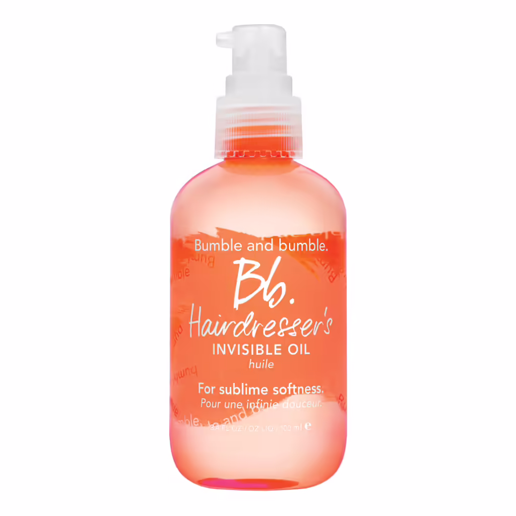 Şeffaf turuncu renkli, beyaz pompalı bir şişede, üzerinde Bb. Hairdresser's Invisible Oil yazan Bumble and bumble saç yağı, kuru saçlara derinlemesine nem kazandıran etkili bir nem rutini için ideal bir üründür.