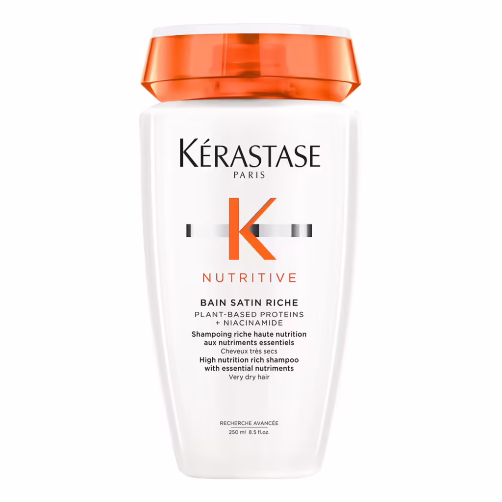 Kérastase Nutritive Bain Satin Riche, bitki bazlı proteinler ve niasinamid içeren, kuru saçlar için yoğun besleyici ve nemlendirici olarak tasarlanmış, turuncu kapaklı 250 ml beyaz şampuan şişesi, etkili bir nem rutini için öneriliyor.