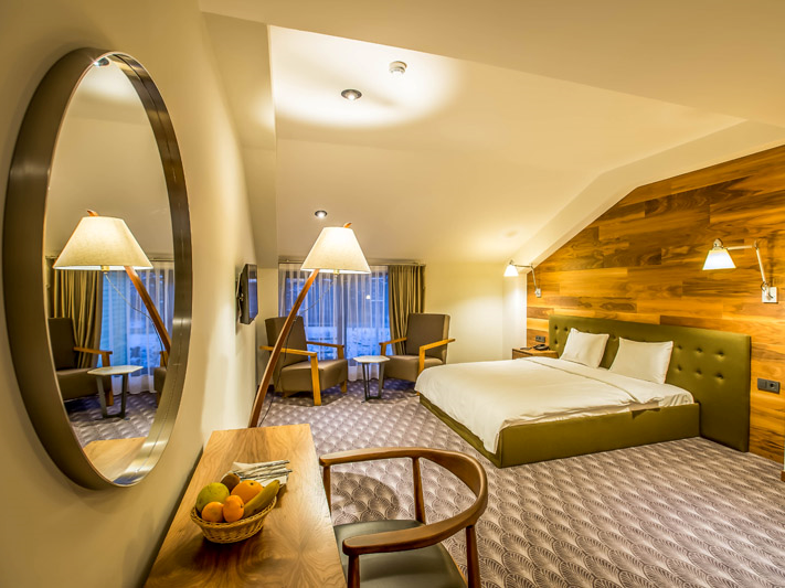 Abant Lotus Otel’de ahşap duvar detaylarıyla sıcak bir atmosfere sahip modern konforlu oda
