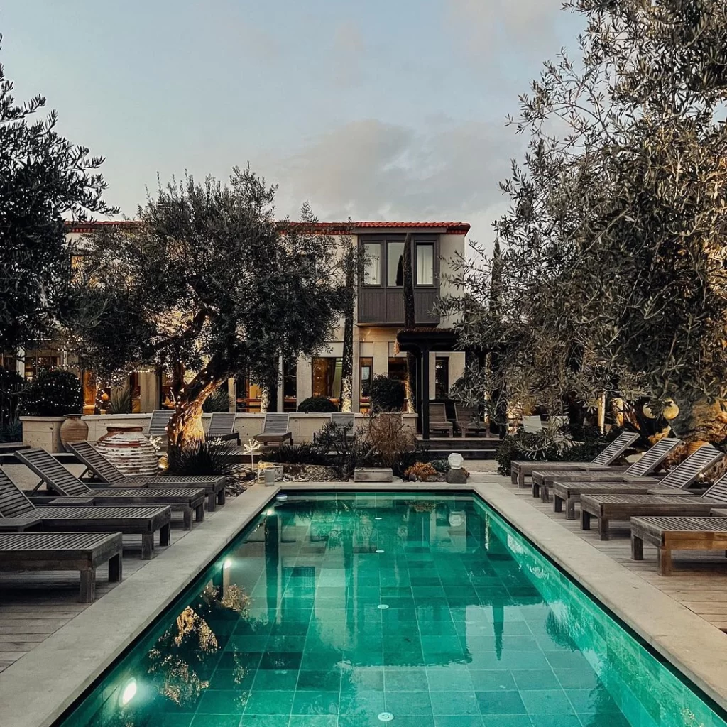 Bernadet Otel’in zeytin ağaçlarıyla çevrili bahçesi ve havuz başında dinlenme alanı