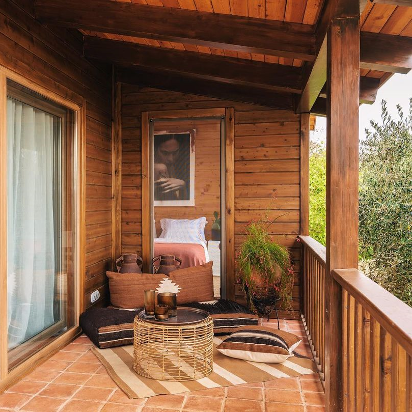 Simurg Inn’de ahşap balkon üzerinde minderli oturma alanı, doğa içinde huzurlu konaklama atmosferi