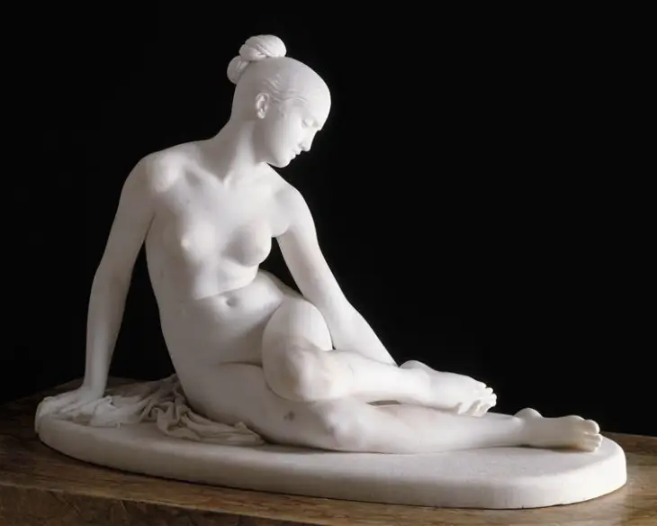 Louvre Müzesi'nde sergilenen bu beyaz mermer heykel, saçları topuz yapılmış, başı aşağı dönük, hafifçe yan dönmüş ve bacakları çapraz uzanmış çıplak bir kadın figürünü siyah bir fon önünde zarifçe betimliyor ve görülmesi gereken eserler listesinde yer alıyor.