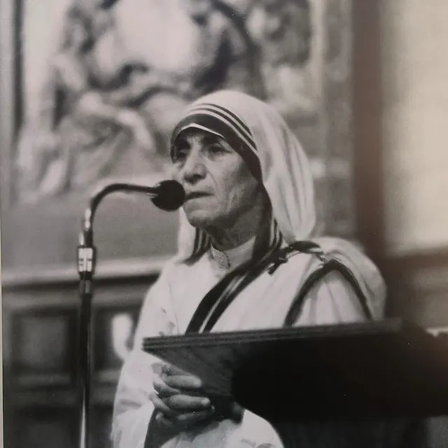 Üsküp’te görmeniz gereken en özel yerlerden biri olan Rahibe Teresa Evi bölümünü tamamlayan bu siyah beyaz fotoğrafta, beyaz başörtülü Rahibe Teresa mikrofon başında ciddi bir ifadeyle konuşurken görülüyor.
