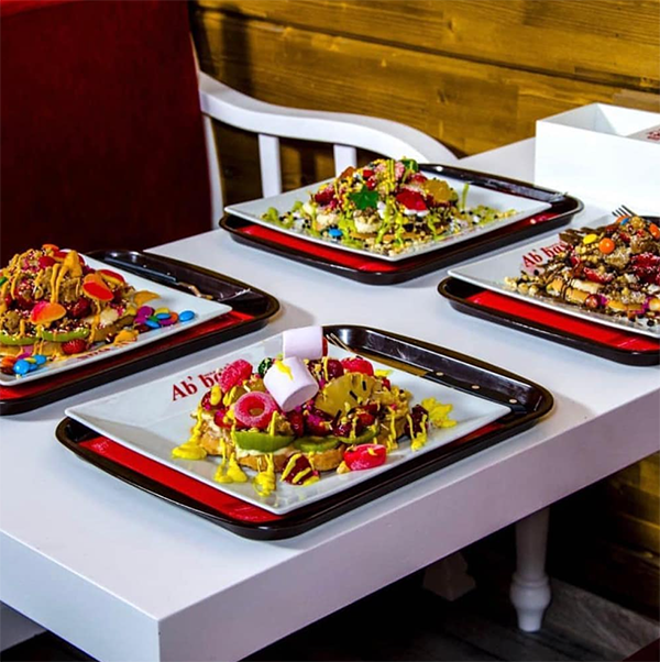 Bebek'in en iyi mekanları arasında yer alan ve lezzetli waffle'larıyla meşhur Ab'bas Waffle'dan, üzerinde taze meyveler, rengarenk şekerlemeler, marshmallow'lar ve çeşitli soslarla zenginleştirilmiş dört adet iştah açıcı waffle tabağı beyaz bir masada sunuluyor.