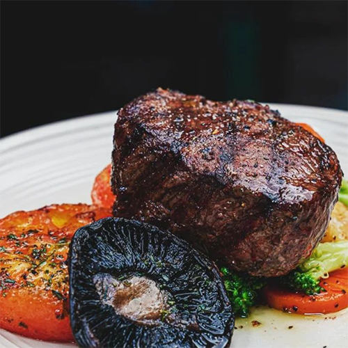 Roma Seyahat Rehberi'nde öne çıkan gastronomik duraklardan birinde servis edilen, bol karabiberle lezzetlendirilmiş, dışı güzelce kızarmış, iri bir portobello mantarı, közlenmiş domates dilimleri ve brokoli eşliğinde iştah açıcı bir dana biftek tabağı.