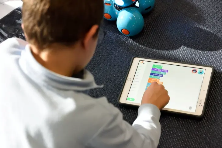 Tablet üzerinden Sago Mini World interaktif oyunları ile problem çözme ve ince motor becerilerini geliştiren çocuk.