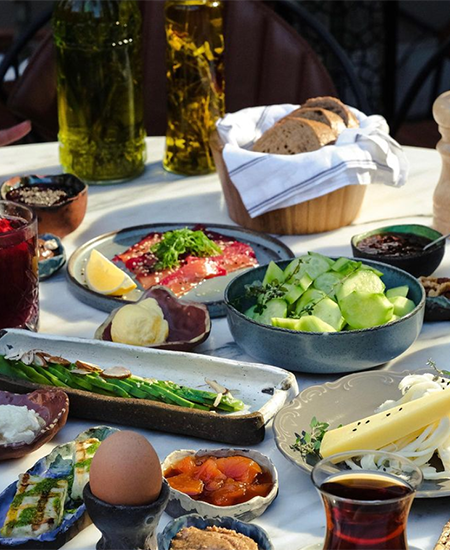 Bebek'in en iyi mekanlarından birinde, haşlanmış yumurta, dilimlenmiş peynirler, taze salatalık, avokado, somon füme, çeşitli reçeller, zeytinyağları ve ekmek sepetiyle sunulan, bölgenin zengin kahvaltı kültürünü yansıtan keyifli ve zengin bir kahvaltı sofrası.