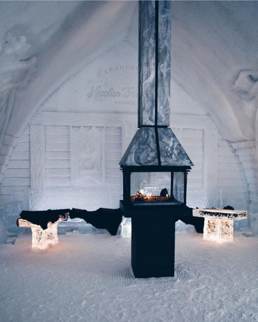 Québec yakınlarındaki Hôtel de Glace'ın buzdaki mimarisiyle dikkat çeken, içinde sıcak bir ateş yanan metal şöminesi ve içten aydınlatmalı buz bankları bulunan, arka planda Nicolas Feuillatte markalı bir dekorasyonun yer aldığı bu özel ortam, dünyanın en iyi buz otelleri deneyimlerinden birini yansıtıyor.