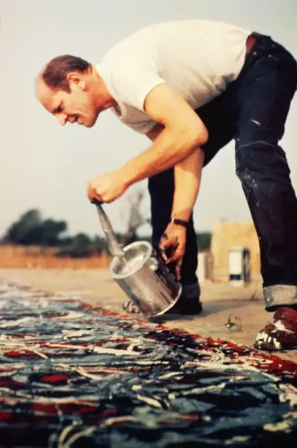 Jackson Pollock’un resim yapma süreci – Yere serilmiş tuval üzerinde damlatma tekniğini uygulayan sanatçı figürü.

