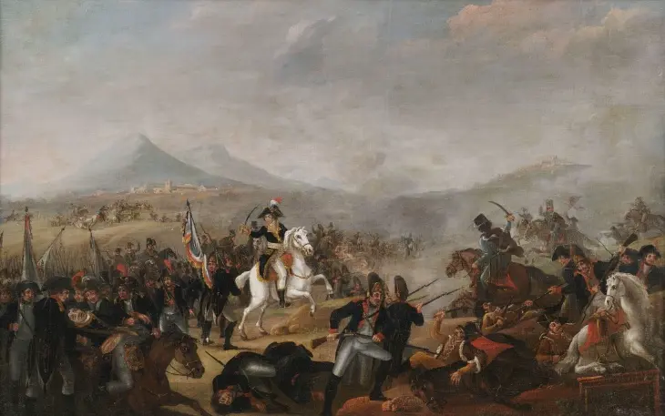 Napoleon Bonaparte'ın hayatından bir kesit sunan bu tarihi tabloda, süvari ve piyade birliklerinin şiddetli bir savaşta çarpıştığı, yerde yatan askerler ve bayrakların bulunduğu bir cephede, beyaz at üstündeki komutanın (muhtemelen Napolyon) ordusunu yönettiği, uzakta ise dağlık arazi ve bir yerleşimin seçildiği görünüyor.