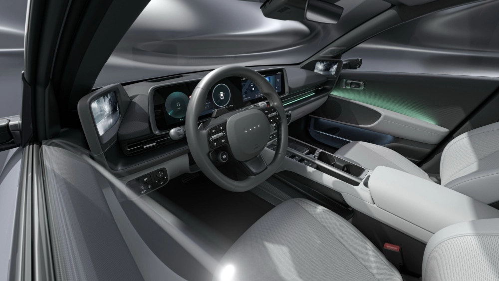 Yeni Hyundai Ioniq 6 elektrikli otomobilin modern ve minimalist iç mekan tasarımını gösteren bu geniş açılı görselde, sürücü koltuğundan bakıldığında dijital gösterge paneli, büyük merkezi ekran, direksiyon simidi, dijital yan ayna ekranları ve yeşil ambiyans aydınlatmalı açık renkli yolcu kapısı paneli belirgin şekilde görünüyor.