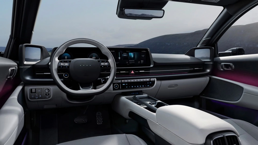Yeni Hyundai Ioniq 6 elektrikli otomobilin şık iç mekan tasarımı; minimalist direksiyon simidi, birleşik dijital gösterge ve bilgi-eğlence ekranı, kapı içlerinde mor ambiyans aydınlatması ve dış manzarayı gösteren dijital yan aynalarıyla fütüristik bir sürüş deneyimi vadediyor.