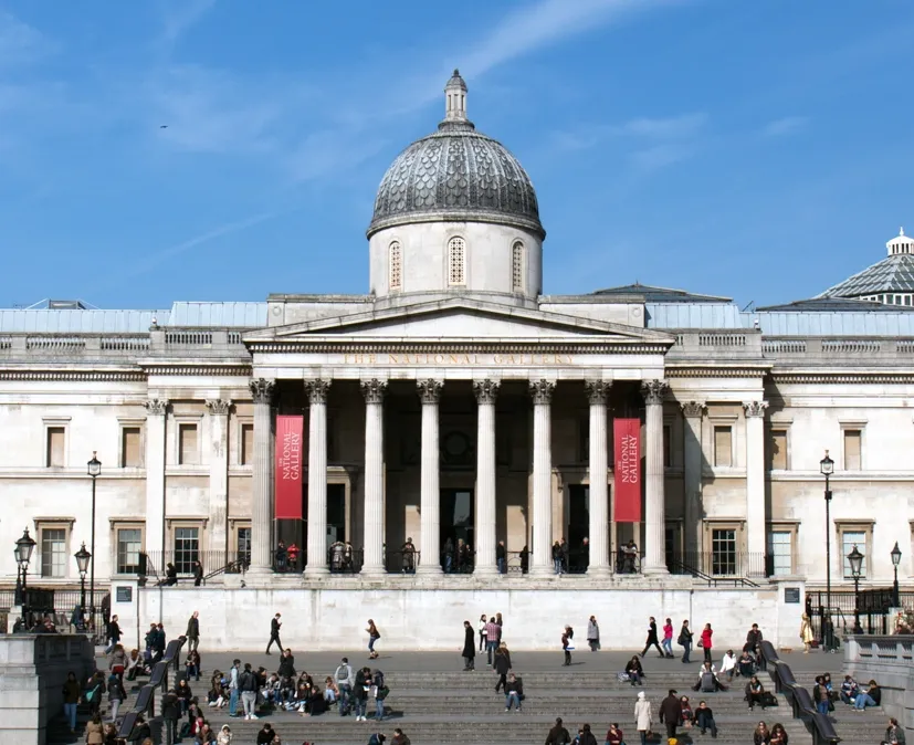 Londra'daki Ulusal Galeri'nin görkemli neoklasik cephesi, ana girişine çıkan geniş basamaklarda dolaşan veya dinlenen çok sayıda insanla birlikte, İngiliz başkentindeki sanat ve kültürün hareketli bir merkezi olarak güneşli bir havada görülüyor.