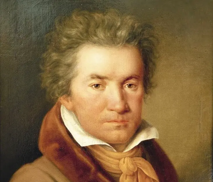 Beethoven'ın hayatı ve eserleri bağlamında, hafifçe dalgın bakışlı, kıvırcık kahverengi saçlı, beyaz yüksek yakalı gömlek, kahverengi palto ve sarı fularıyla görülen, klasik dönemin önemli bestecisi Ludwig van Beethoven'ın detaylı bir yağlıboya portre tablosu.