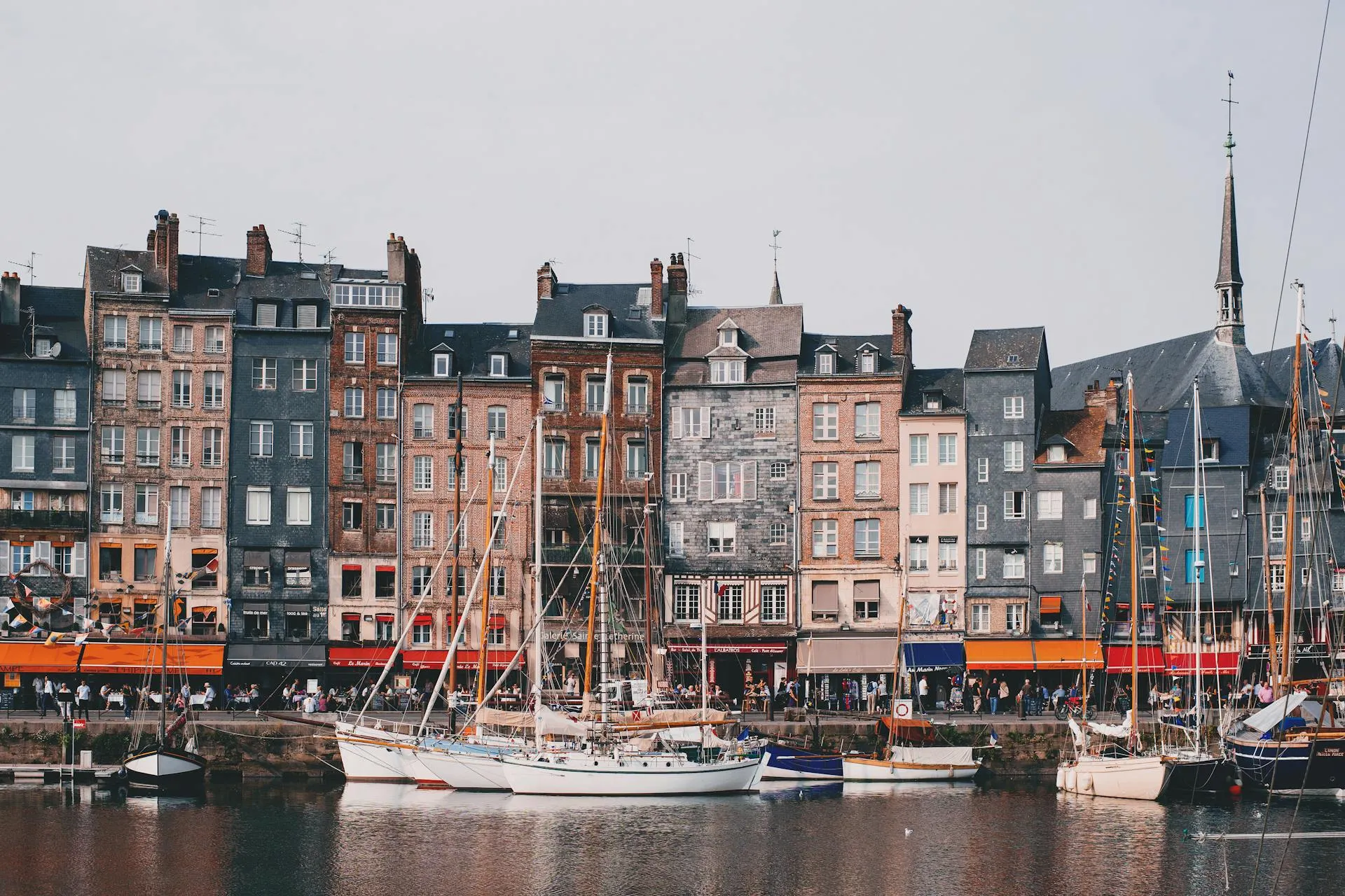 Honfleur Fransa’da Vieux Bassin limanında renkli tarihi evler ve yelkenliler
