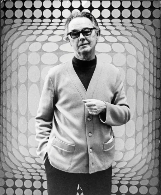 Op Art sanat akımının önde gelen temsilcilerinden Macar asıllı Fransız ressam Victor Vasarely, karakteristik kalın çerçeveli gözlükleri, koyu renk boğazlı kazağı ve açık renk hırkasıyla, dalgalı formda optik illüzyon yaratan bir Op Art eseri önünde kameraya bakıyor.