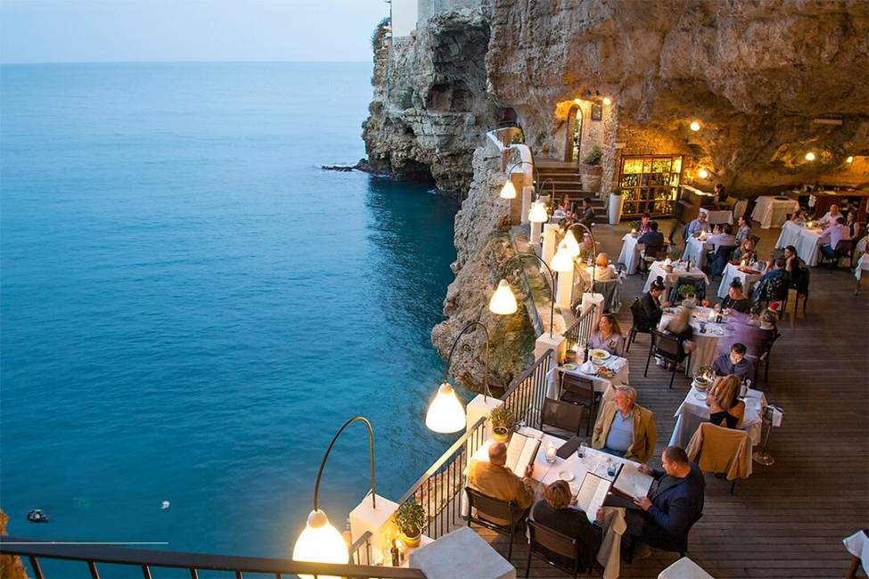 Grotta Palazzese Restaurant, deniz seviyesinin üzerinde, doğal bir mağaranın içine yerleştirilmiş açık hava terası; doğanın mimariyle kusursuz biçimde birleştiği, eşi benzeri olmayan bir atmosfer sunuyor.