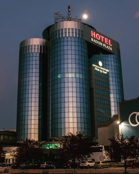 Saraybosna'nın modern yüzünü yansıtan, cam cepheli ve ışıklı HOTEL RADON PLAZA tabelasıyla gecenin karanlığında yükselen, parlak dolunayın eşlik ettiği bu otel, Bosna-Hersek gezi rehberinin lüks konaklama seçeneklerinden biri olarak dikkat çekiyor.