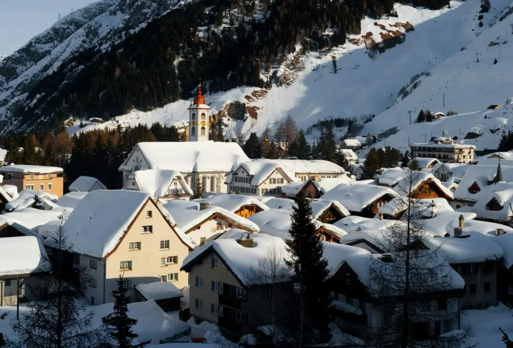 İsviçre Alplerinde yer alan Andermatt köyü – karla kaplı çatıları ve arka plandaki dağ manzarasıyla kışın büyüleyici atmosferi