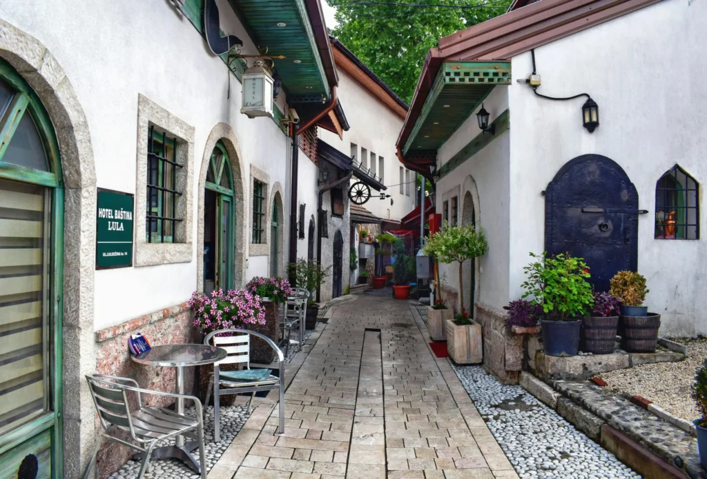 Aydınlık beyaz cepheli, yeşil ahşap detaylara sahip binaların sıralandığı dar, taş döşeli bir Bosna-Hersek sokağında yer alan Hotel Baština Lula tabelası, sokağa bakan masaları ve rengarenk çiçekleriyle otantik bir seyahat deneyimi vadediyor.