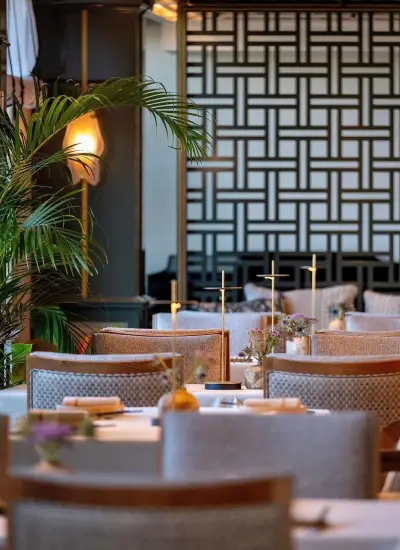 İstanbul'da modern iç mekân tasarımıyla dikkat çeken Gallada & Topside Bar; şık masa düzeni ve geometrik duvar dekorlarıyla fine dining ambiyansı.