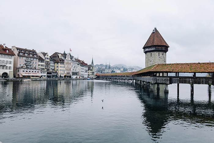 İsviçre’nin Luzern kentinde yer alan tarihi Kapellbrücke (Şapel Köprüsü) ve su kulesi – göl üzerinde yansıyan şehir manzarası