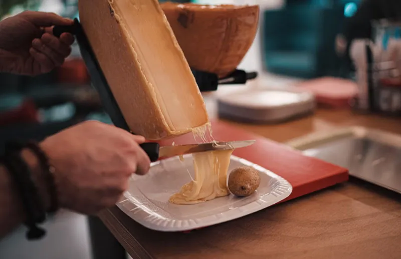 İsviçre’ye özgü Raclette peynirinin eritilerek patates üzerine servis edildiği geleneksel sunum