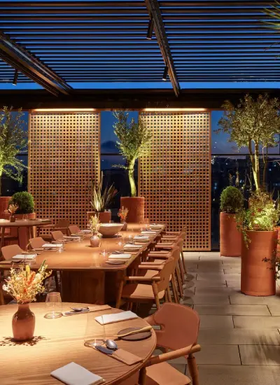 TURK by Fatih Tutak restoranının akşam ambiyansında sıcak tonlar, teras manzarası ve modern masa düzeniyle fine dining deneyimi.