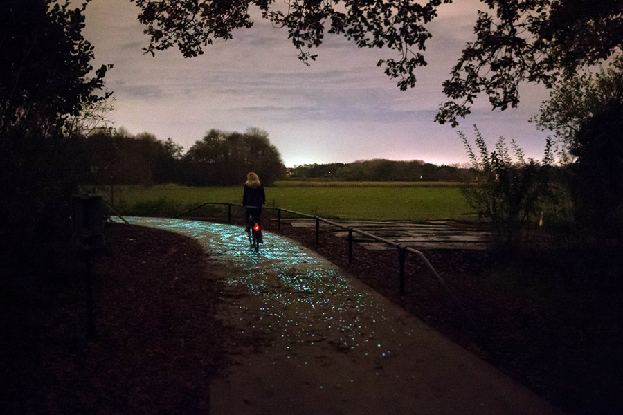 Hollanda'daki Van Gogh-Roosegaarde bisiklet yolu, Vincent van Gogh'un Yıldızlı Gece tablosundan esinlenmiş parıldayan zeminiyle karanlıkta ilerleyen bir bisikletli kadını gösteriyor; etrafı ağaçlar ve uzak şehir ışıklarıyla çevrili bu büyüleyici güzergah, dünyanın en iyi bisiklet rotaları arasında eşsiz bir deneyim sunuyor.