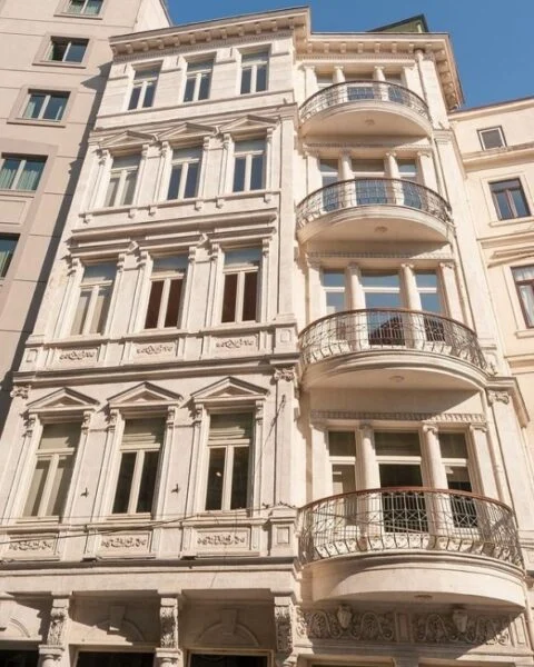 İstanbul Araştırmaları Enstitüsü Kütüphanesi'nin 19. yüzyıl sonu mimarisini yansıtan, detaylı süslemeleri ve sağ tarafında yer alan demir parmaklıklı kavisli üç balkonuyla dikkat çeken, açık renkli tarihi dış cephesi, şehrin en iyi kütüphaneleri arasında zamansız bir bilgi yuvası olarak yükseliyor.