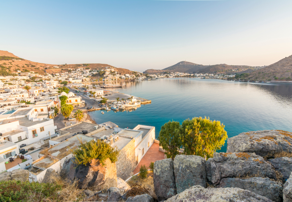 Patmos'ın tepeden görünen bu büyüleyici panoramasında, Ege'nin masmavi sularına nazır, bembeyaz evlerle dolu pitoresk sahil kasabası ve sakin koydaki tekneler, kapıda vize kolaylığıyla ulaşılabilen Yunanistan adalarının eşsiz güzelliğini gözler önüne seriyor.