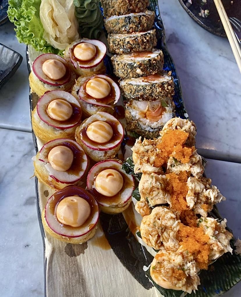 İstanbul'un popüler sushi restoranlarından birinde, farklı lezzetler sunan özel bir tabak: turp dilimli ve kremalı soslu taze rulo sushiler, çıtır pane kaplı somonlu rollar ve bol havyarlı, yengeç etli iştah açıcı sushiler zarif bir şekilde sunuluyor.
