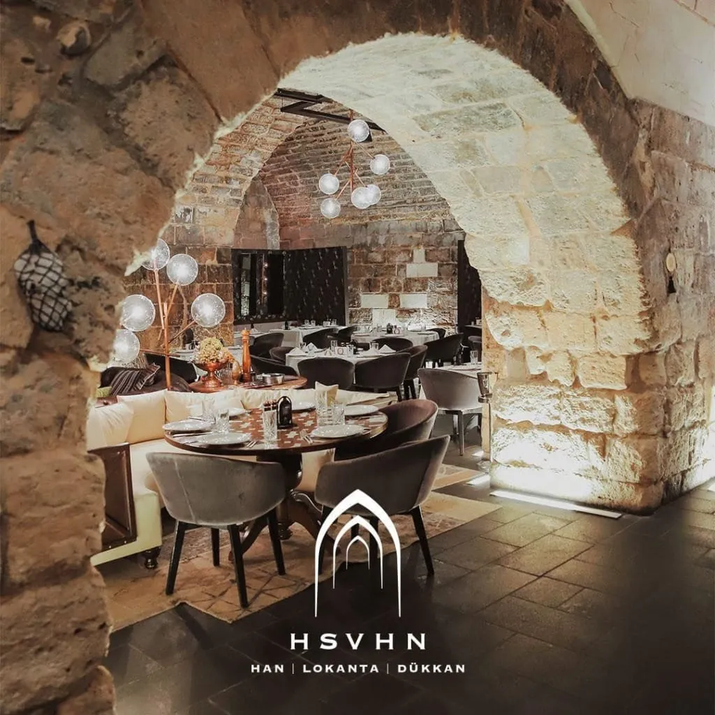 Gaziantep’te Hışvahan’ın taş kemerlerle çevrili restoran bölümü, zarif dekorasyon ve modern aydınlatmalar eşliğinde otantik bir yemek deneyimi sunuyor.