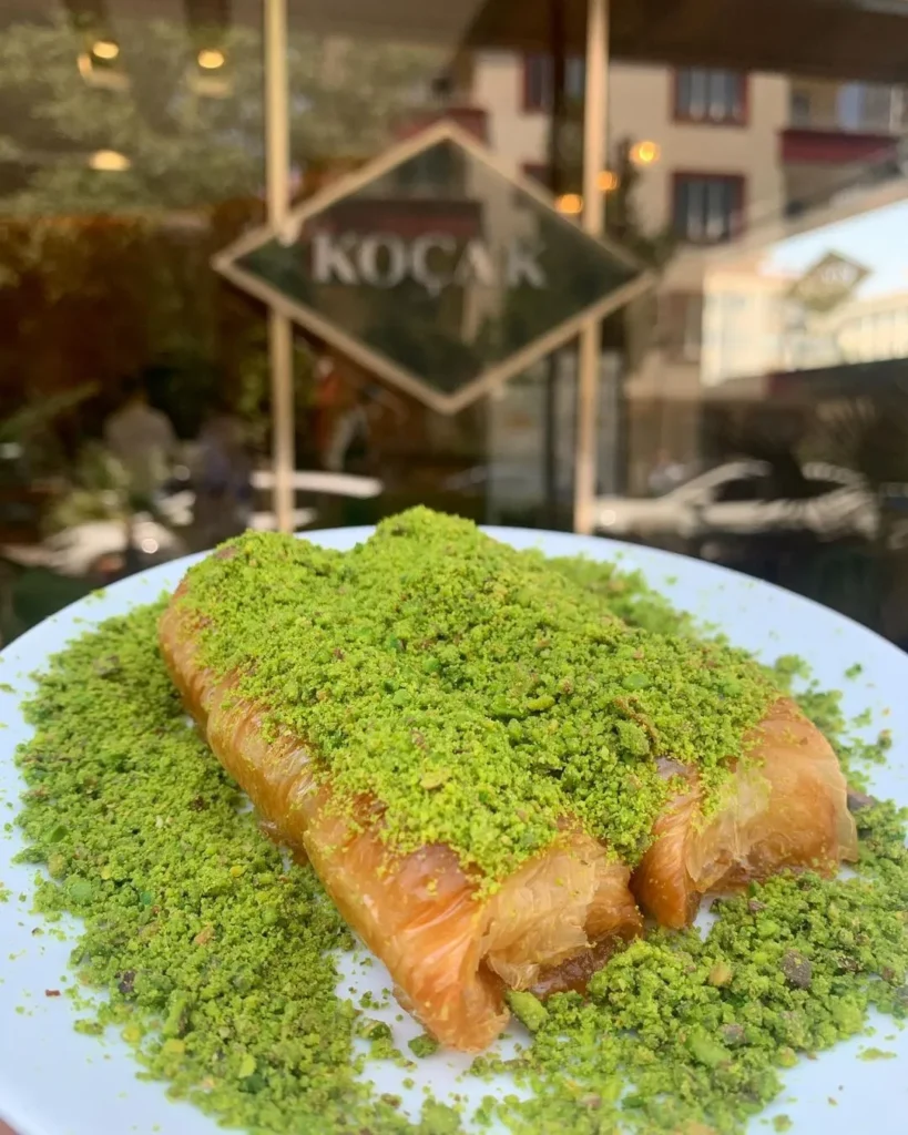 Gaziantep’te Koçak Baklava’da servis edilen fıstık kaplı taze baklava, şehrin ünlü tatlı kültürünü yansıtıyor.