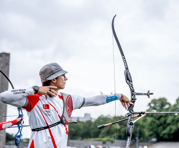 Marka Adı: HOYT
Ürün Adı: HOYT Erkek Olimpik Recurve Okçuluk Yayı
Ürün Cinsiyeti: Erkek
Ürün Tipi: Okçuluk Ekipmanı
Ürün Sezonsallığı: Belirtilmemiş
Ürün Çeşidi: Olimpik Okçuluk Yayı
Ürün Özellikleri: Bu profesyonel okçuluk ekipmanı, özellikle olimpik düzeyde rekabetçi kullanım için tasarlanmış HOYT marka bir recurve yaydır. Mat siyah renkteki yay, gelişmiş bir nişangah sistemi, denge çubuğu ve hassas ok yatağı gibi yüksek performanslı aksesuarlarla donatılmıştır. Ergonomik tasarımı sayesinde atış stabilitesini ve isabet oranını artırırken, dayanıklı hafif alaşım veya karbon fiber malzemelerden üretildiği varsayılabilir. Sporcunun üzerinde görülen Türk bayraklı forma, özel okçu kol koruyucu, göğüs koruyucu ve parmak koruyucu gibi diğer ekipmanlar, tam bir profesyonel okçuluk setini tamamlar.
Öne Çıkan Detaylar:
- HOYT markalı, olimpik standartlarda recurve yay
- Gelişmiş nişangah, denge çubuğu ve ok yatağı gibi hassas aksesuarlar
- Türkiye Okçuluk Federasyonu logosu ve Türk bayrağı detaylarına sahip sporcu kıyafeti
Kimler Kullanıyor?: Okçuluk sporuna tutkuyla bağlı, uluslararası arenalarda rekabet etmeyi hedefleyen veya antrenmanlarında en üst düzey performansı arayan sporcular bu ekipmanı tercih edebilir. İsabetliliği, gücü ve dayanıklılığı bir arada arayan, modern ve teknik tasarıma önem veren okçular için idealdir. Olimpiyat ruhunu taşıyan, disiplinli ve hedef odaklı her birey bu profesyonel okçuluk setinde kendini bulacaktır.
