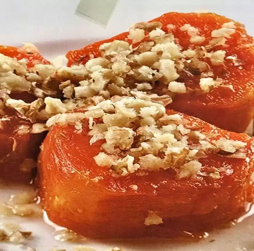 Parlak turuncu renkte, bol ceviz içi serpilmiş ve şerbetiyle parlayan üç dilim kabak tatlısı, Antalya mutfağının vazgeçilmez lezzetlerinden biri olarak şehirdeki en iyi restoranlarda deneyimlenebilecek geleneksel bir tatlıyı sunuyor.