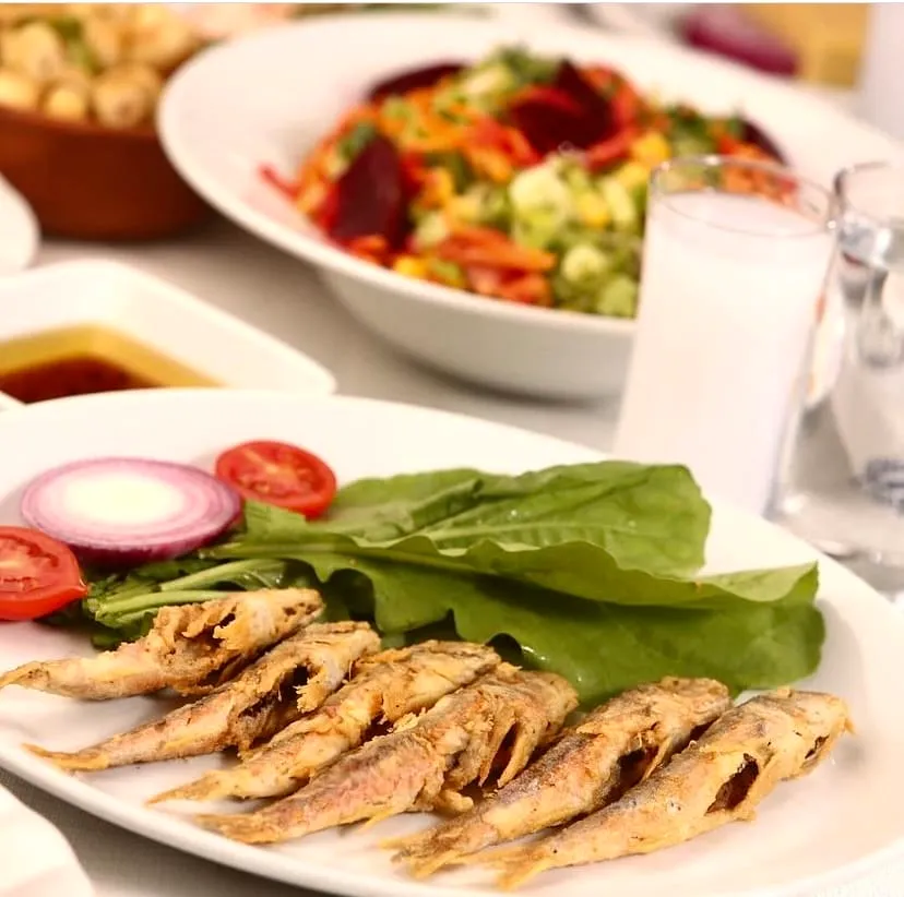 Yakup 2, Beyoğlu'nda rakı sofrasında kızarmış hamsi tabağı, roka, soğan ve salata eşliğinde