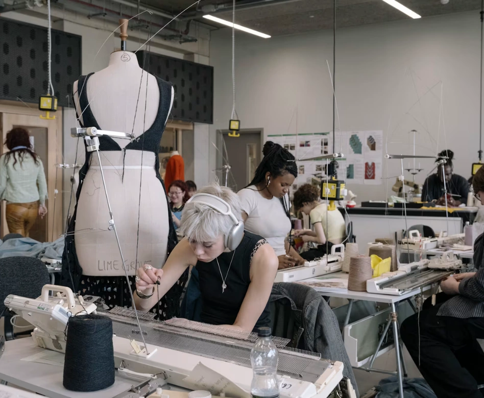 Dünyanın en iyi moda okullarından birinde, öğrenciler bir stüdyoda örgü makinelerinde kumaş tasarımları üzerinde yoğunlaşırken, bir yandan da manken üzerinde giysi formları oluşturuyorlar, geleceğin moda profesyonelleri için dinamik bir yaratım ortamını gözler önüne seriyor.