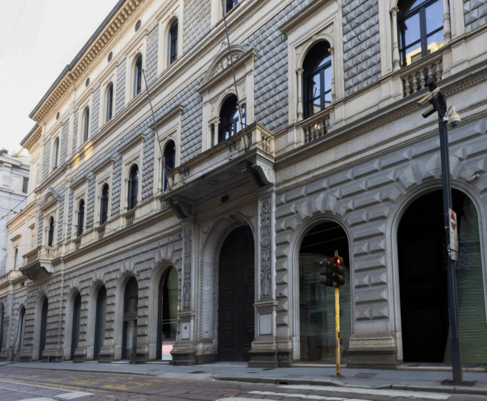 Dünyanın en iyi moda okullarından Istituto Marangoni'nin kampüs binası olduğu anlaşılan, zarif kemerli pencereleri, üst katlarda balkonları, kabartmalı taş işçiliğiyle süslenmiş çok katlı görkemli bir yapının, kaldırım ve trafik ışığı bulunan bir cadde üzerindeki dış cephesi görülüyor.
