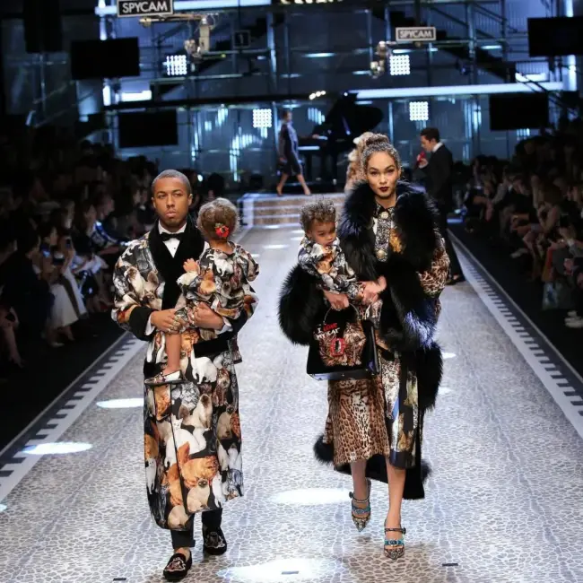 Dolce & Gabbana defilesinde podyumda kürk detaylı, aynı desenli kıyafetler giymiş ebeveynler ve çocukları.