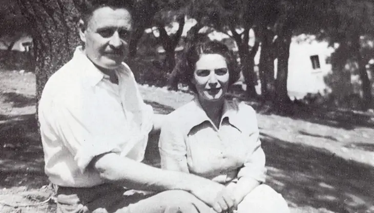 Nazım Hikmet, Münevver Andaç ile birlikte ağaçlık bir alanda oturuyor, samimi bir poz.