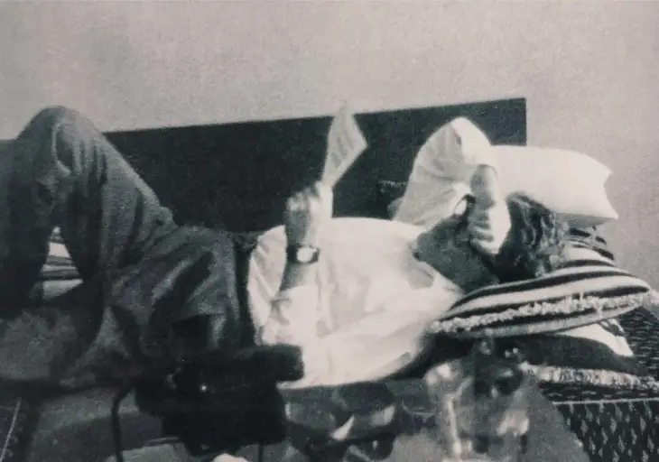 Nazım Hikmet, yatağında sırt üstü uzanmış şekilde bir kağıt okuyarak dinleniyor.