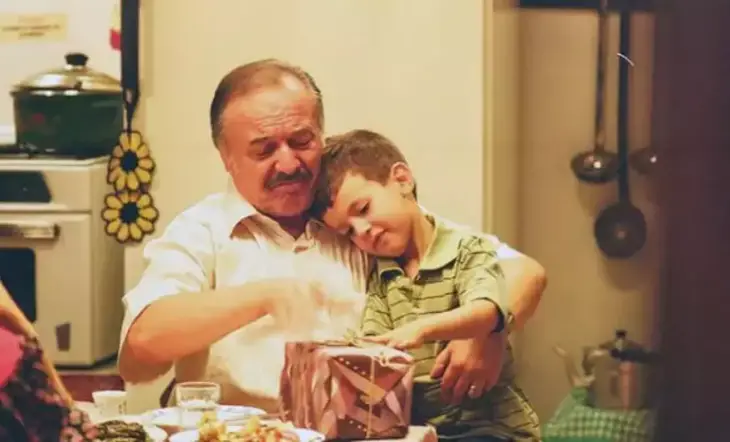 Babam ve Oğlum filminde Çetin Tekindor'un canlandırdığı Hüseyin karakteri, torunuyla birlikte hediye açarken.