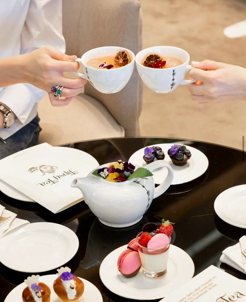 Raffles Istanbul’da Tipsy Tea konsepti – alkollü çay fincanları, çiçek süslemeli masa düzeni ve tatlı tabakları